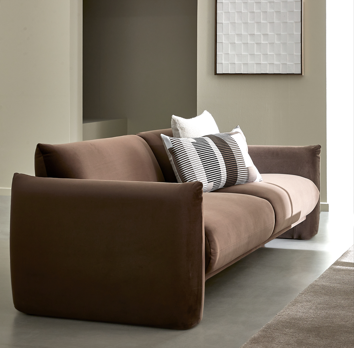 Brun moderne sofa med puder i en lys, minimalistisk stue.