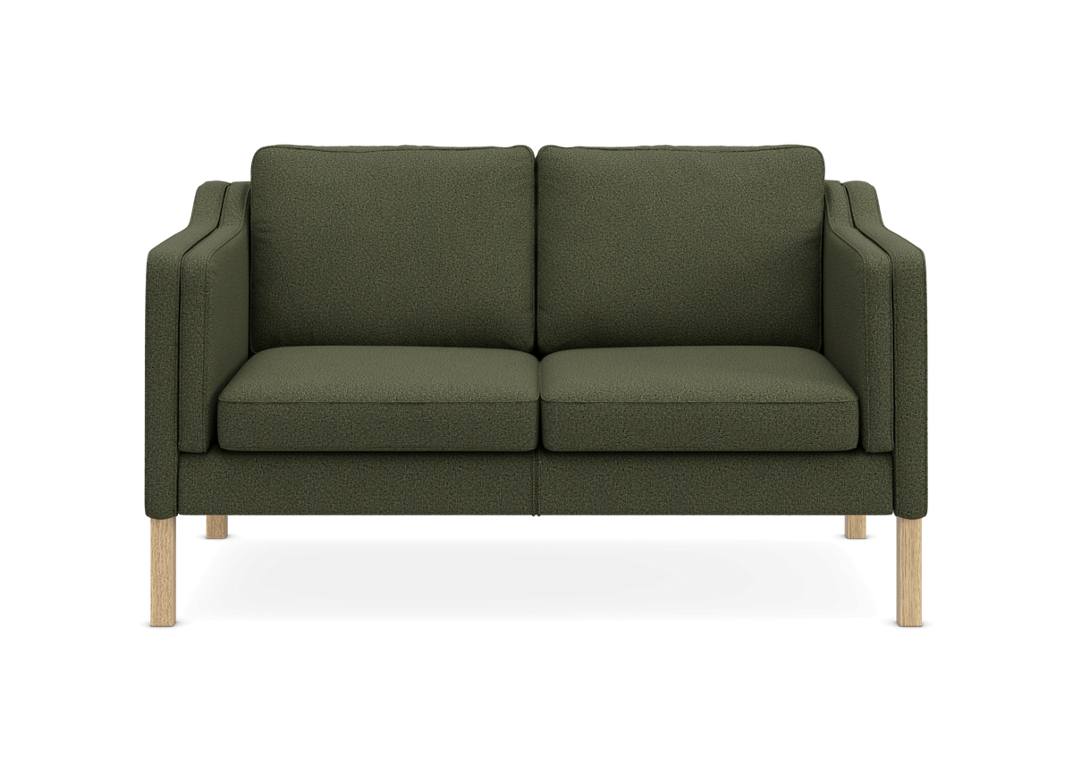Grøn 2-personers sofa med træben, set forfra mod hvid baggrund.