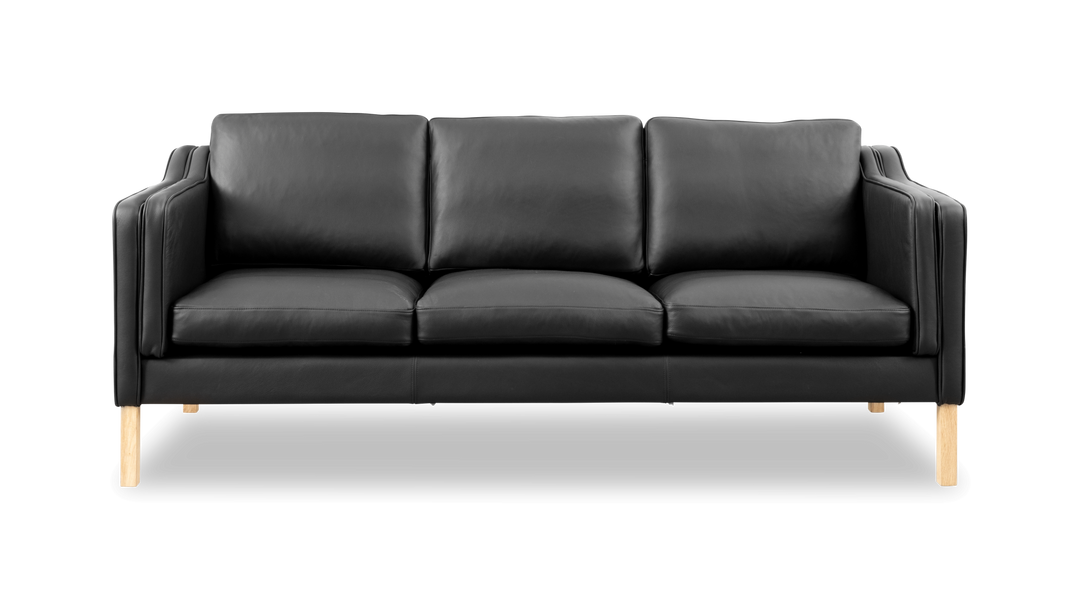 Sort lædersofa med tre sæder og lyse træben, set forfra.