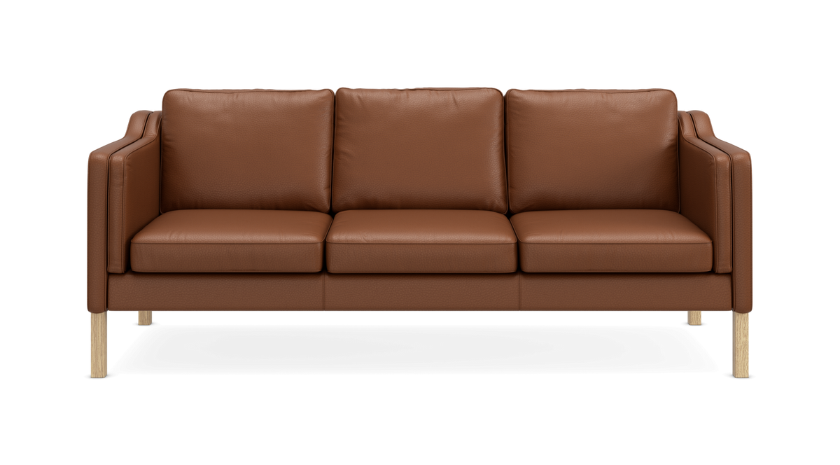Forfra: brun lædersofa med tre sæder og træben på sort baggrund.