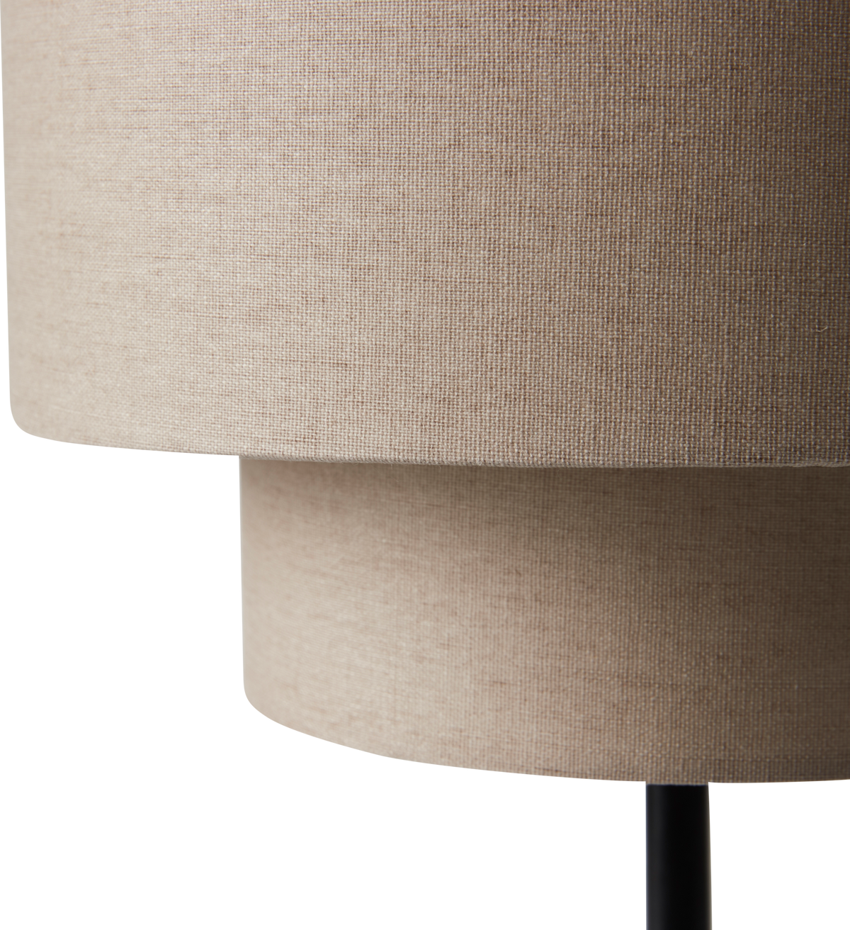 Nærbillede af en beige tekstil lampeskærm i to lag på sort stativ mod hvid studiebaggrund.