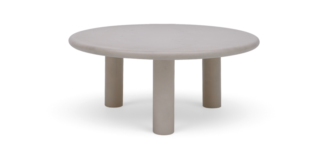 Rundt beige sofabord med tre cylindriske ben.