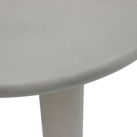 Nærbillede af rund lysegrå bordplade med cylinderben i studie.