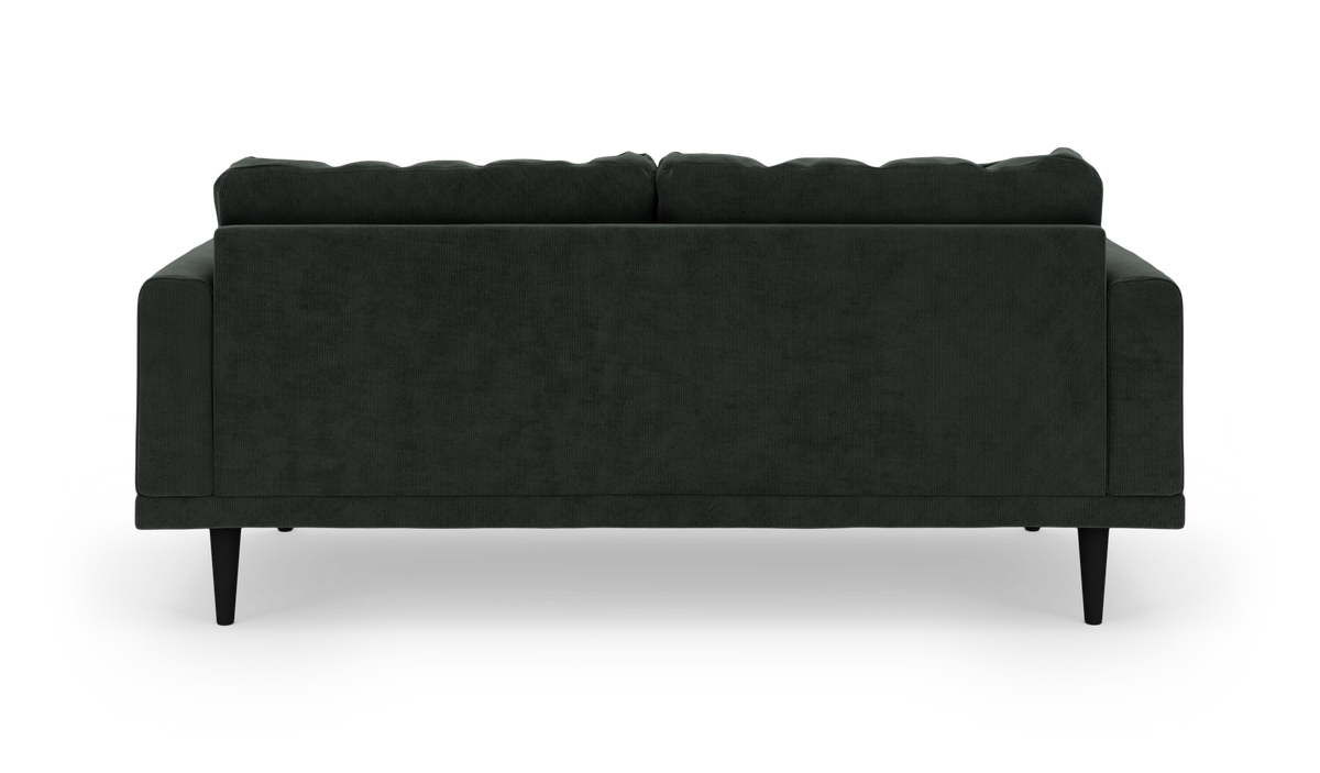 Mørkegrøn sofa set bagfra mod hvid studiebaggrund.