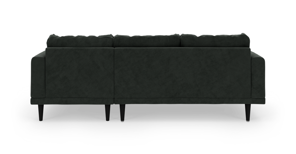 Mørkegrøn stofsofa set bagfra på hvid studiebaggrund.