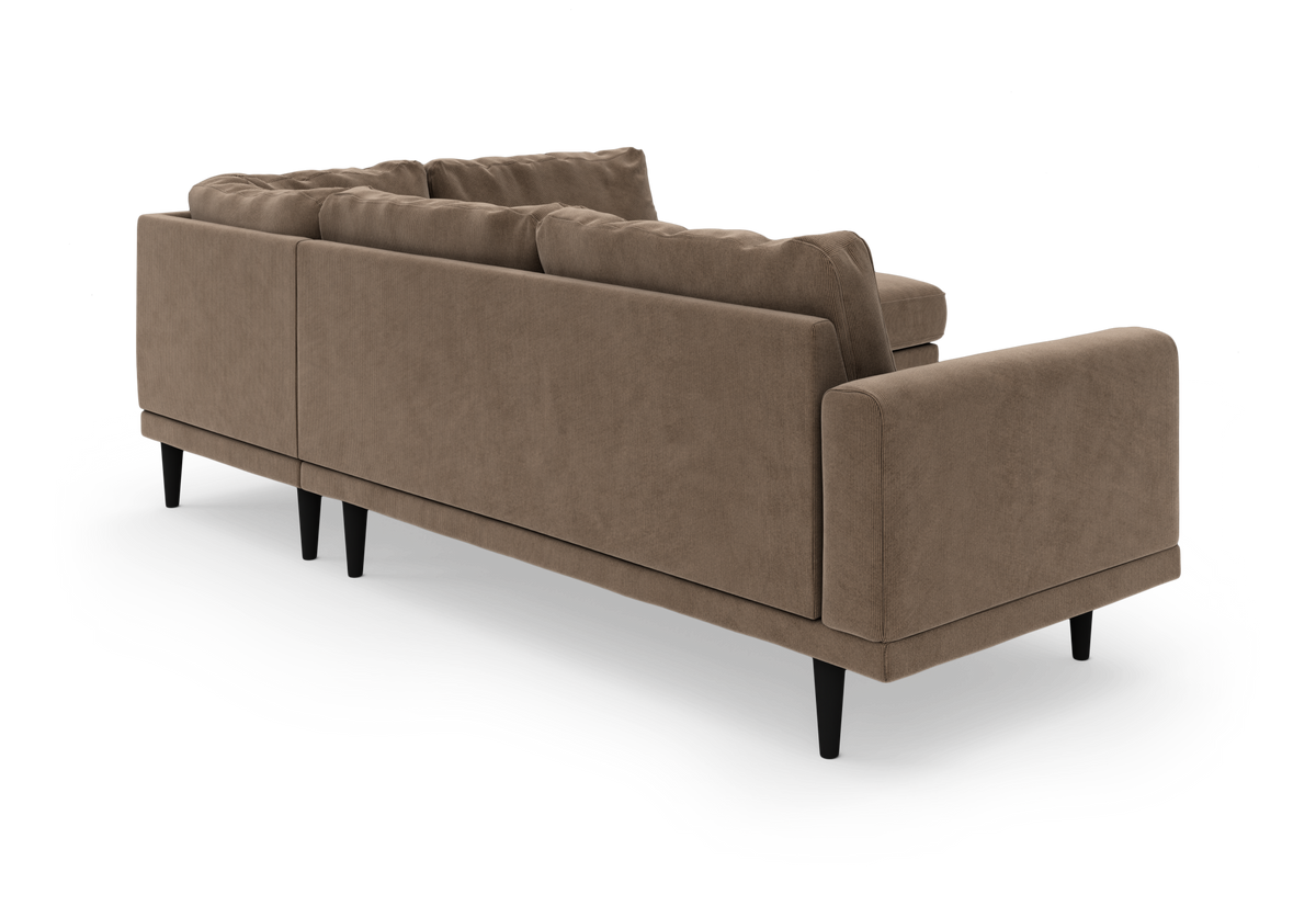 Brun sofa i corduroy-lignende stof med slanke sorte ben, set skråt bagfra på hvid baggrund.
