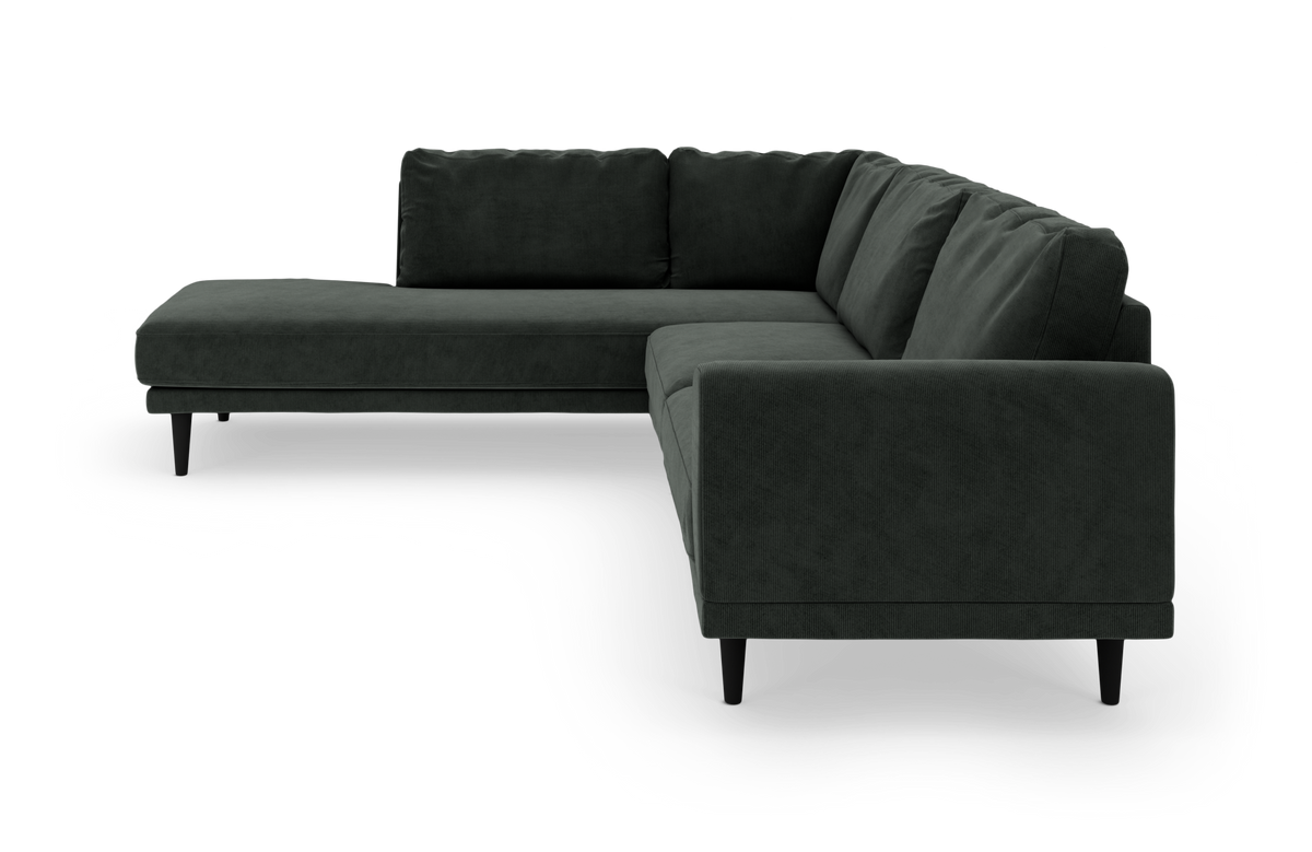 Mørkegrøn L‑formet hjørnesofa med chaiselong til venstre, slanke sorte ben og løse ryghynder.