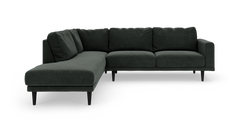 Mørkegrøn L-formet stofsofa med slanke sorte ben.