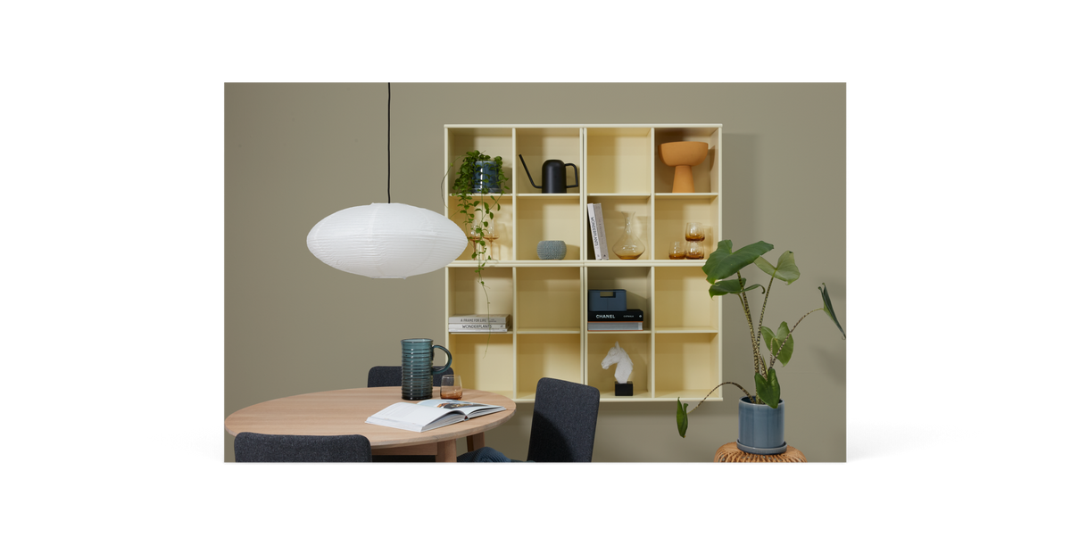 Minimalistisk sort mockup med en stor stående ram, ovalt spejl, bord og en potteplante.