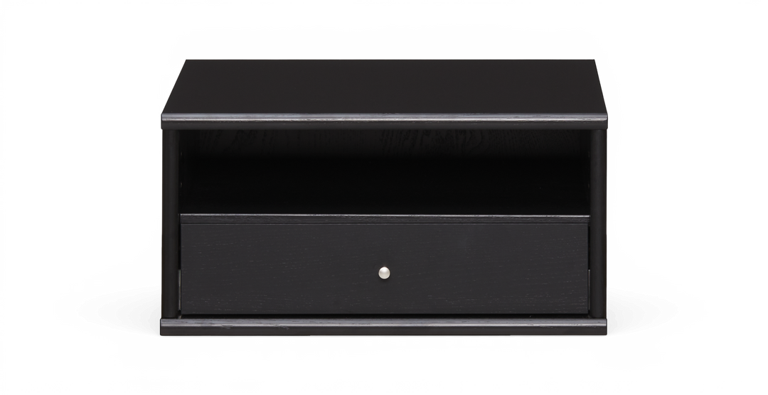 Sort lav tv-bænk/natbord med åben hylde og én skuffe med rund knop, frilagt på hvid baggrund.