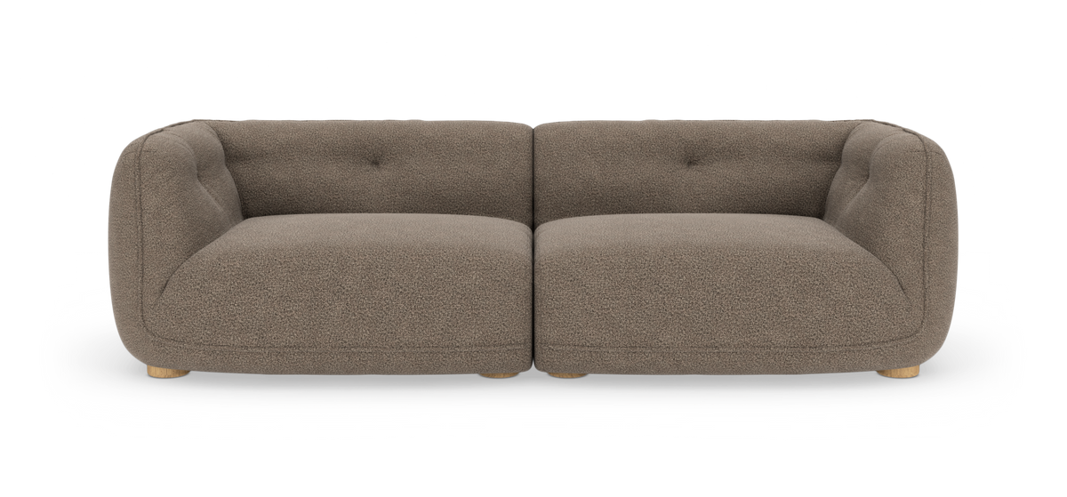 Frontvisning af en to-sæders modulsofa i taupe bouclé med afrundede armlæn og lave træfødder, frilagt mod hvid studiobaggrund.