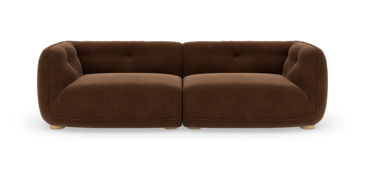 Brun, rund to-sæders modulsofa i bouclé med lyse træben, frilagt mod hvid baggrund.