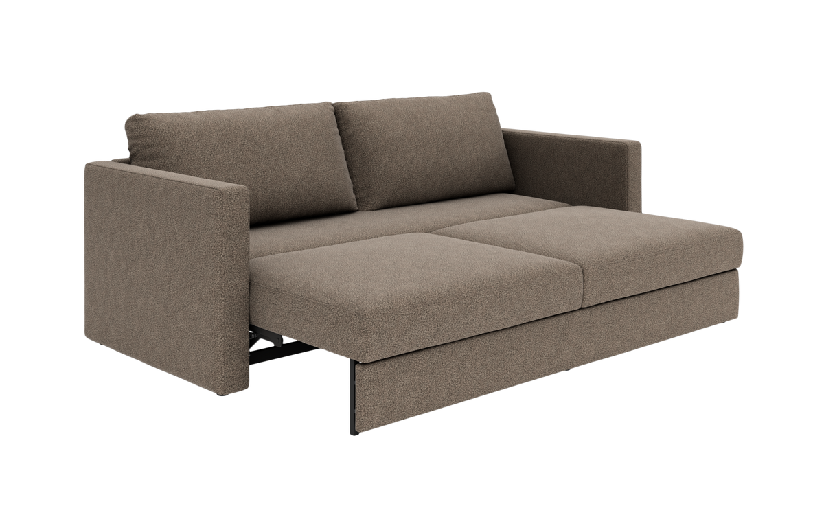 Brun sovesofa i stof, trukket ud til seng med to ryghynder og lige armlæn, frilagt.