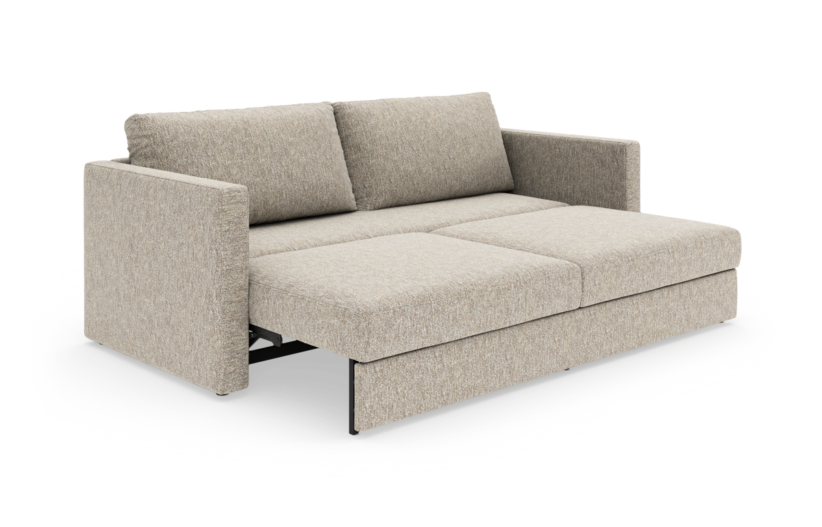 Beige sovesofa i stof med udtræksseng, frilagt i studie.