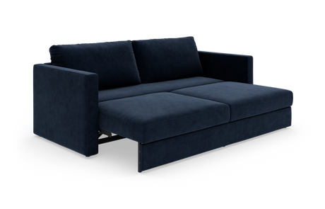 Mørkeblå sovesofa i velour med udtrukket liggedel, fotograferet skråt forfra på hvid studiebaggrund.
