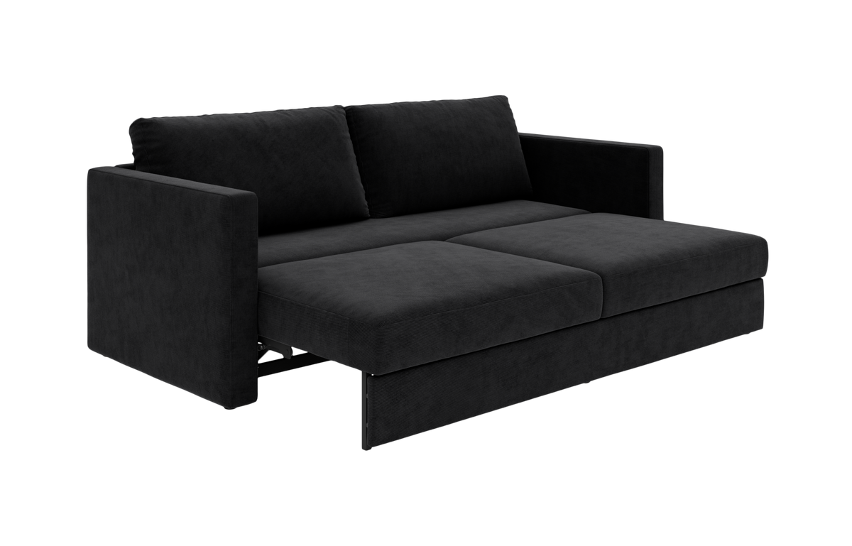 Sort sovesofa med udtrukket sæde i studiemiljø, vist forfra i vinkel.