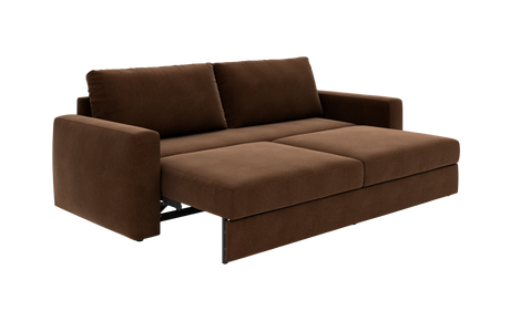 Brun sovesofa i stof, trukket ud til sengeposition med to ryghynder og kraftige sædehynder.
