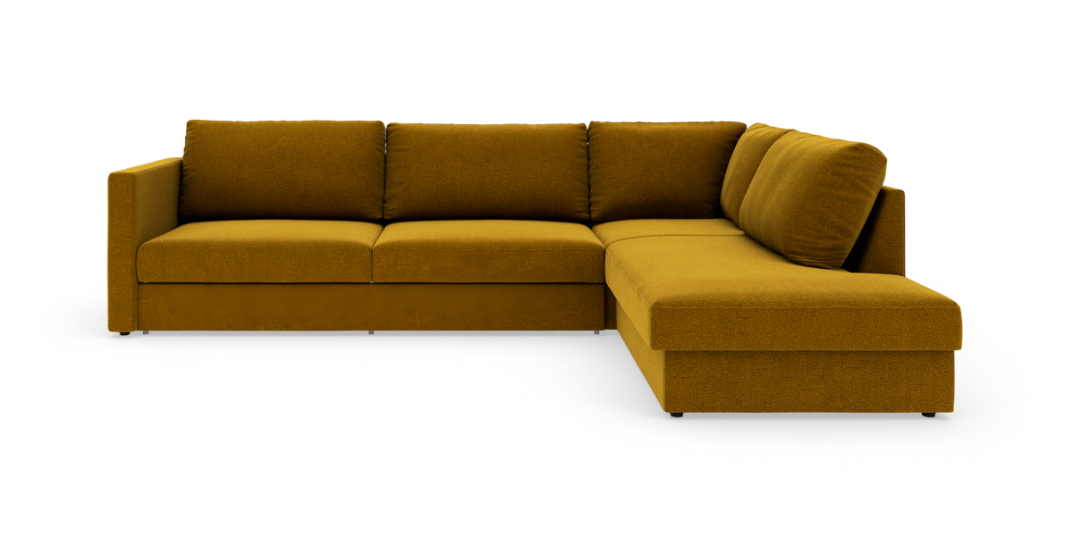 Modulsofa i L-form med højrevendt chaiselong i mustardgul stof på hvid baggrund.