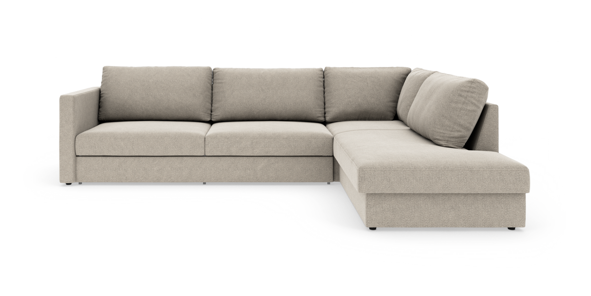 Beige L-formet modulsofa med chaiselong til højre i studiemiljø.