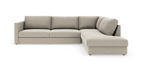 Beige L-formet modulsofa med chaiselong til højre i studiemiljø.