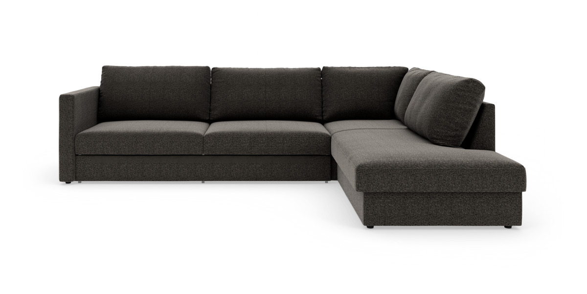 Mørkegrå L‑sofa med chaiselong til højre, fotograferet i studie på hvid baggrund.
