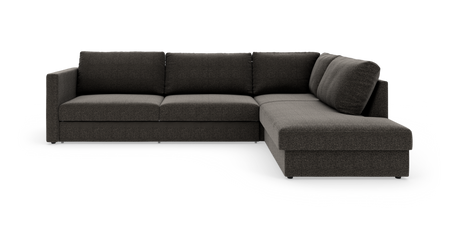 Mørkegrå L‑sofa med chaiselong til højre, fotograferet i studie på hvid baggrund.