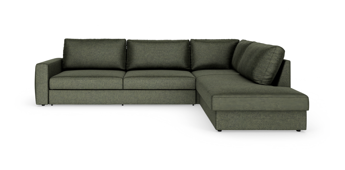 Grøn L‑sofa med chaiselong til højre, tre sæder og løse ryghynder, frilagt mod hvid baggrund.