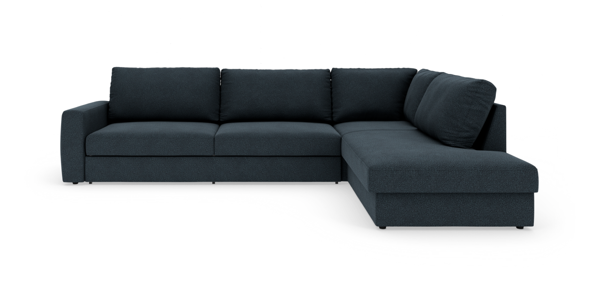Mørkeblå L‑sofa med højrevendt chaiselong, tre sæder og kraftige ryghynder i studieopsætning.