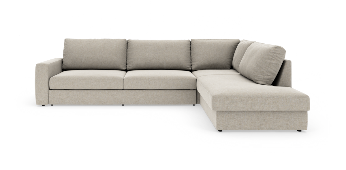 Beige L-formet modulsofa med chaiselong til højre, tre sædehynder og brede armlæn, frilagt mod hvid baggrund.