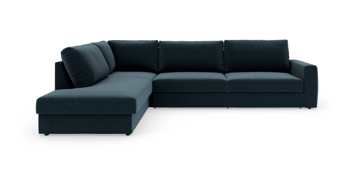 Mørkeblå L‑sofa med chaiselong til venstre, fotograferet i studie mod hvid baggrund.