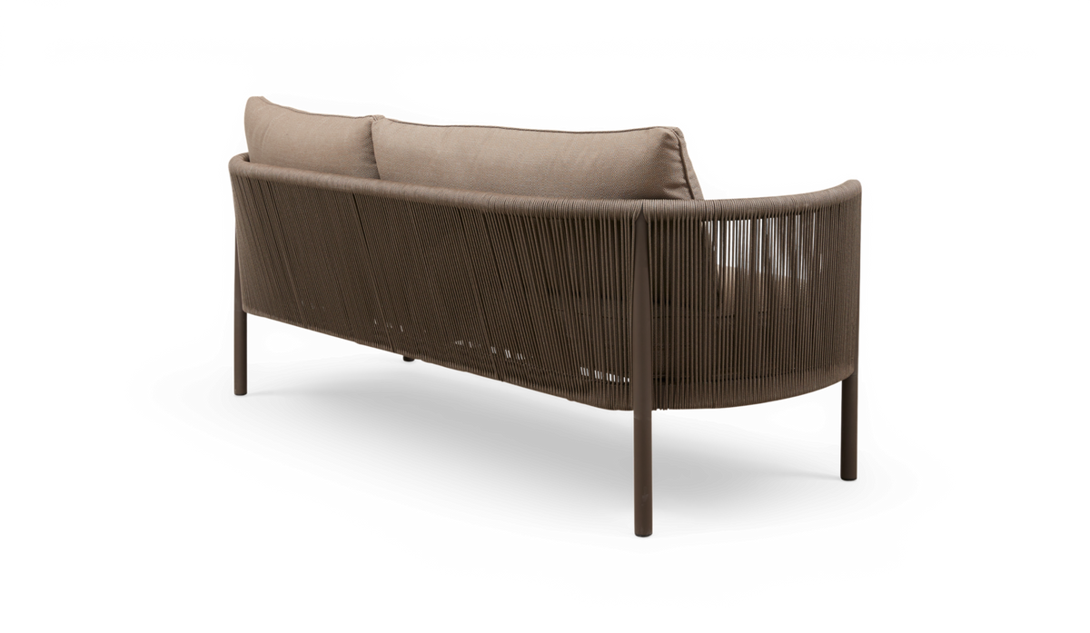 Bagfra i skrå vinkel af brun/beige 3-personers sofa med afrundede hjørner, flettet rebryg og løse ryghynder, frilagt på hvid baggrund.
