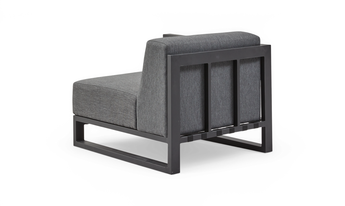 Grå modul lounge-stol med sort metalramme set skråt bagfra på hvid baggrund.