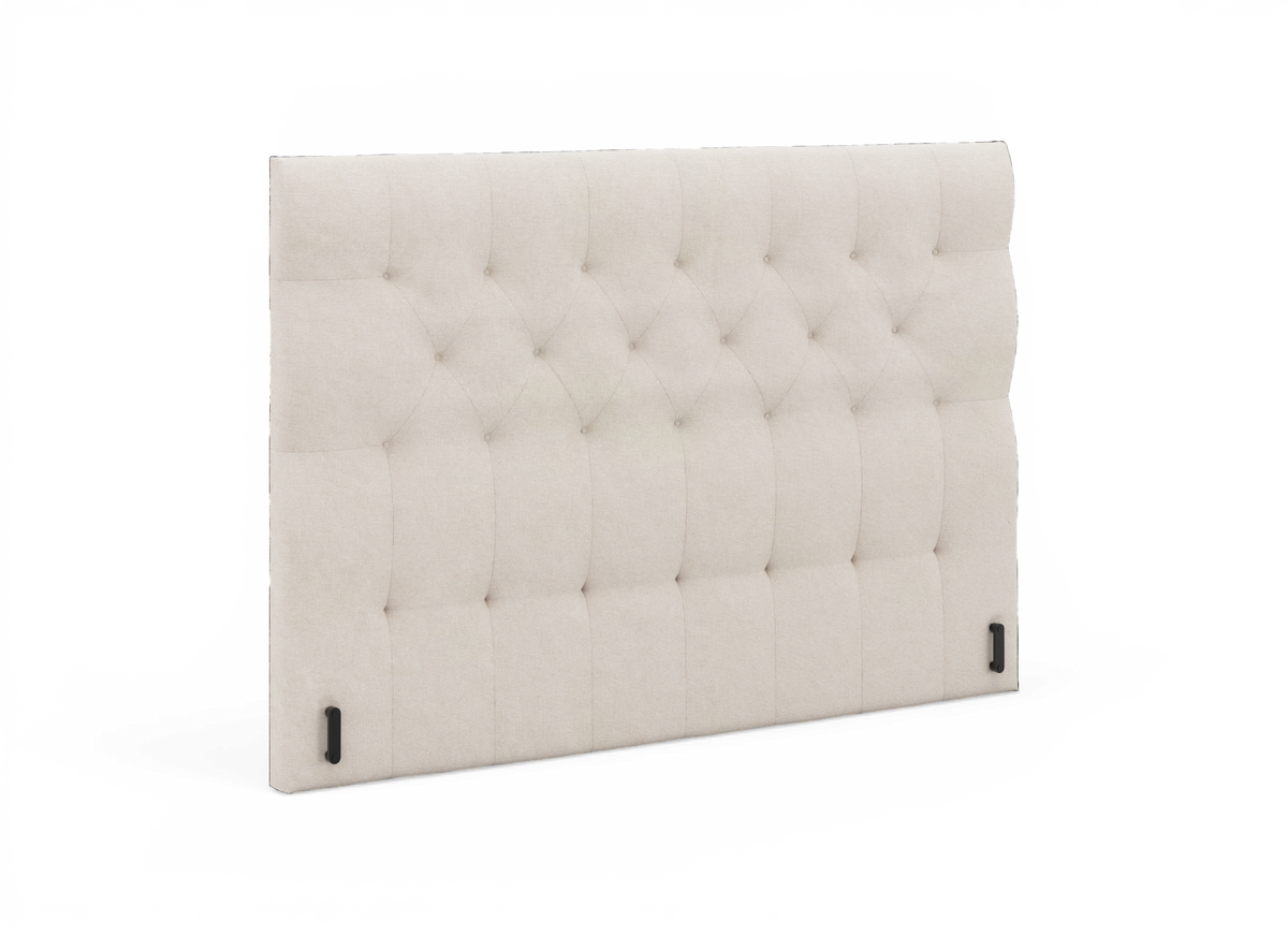 Beige, knapstukket sengegavl i tekstil, let vinklet produktfoto.