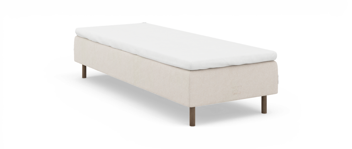 Beige sengesokkel med hvid topmadras og træben, enkeltseng i minimalistisk stil.