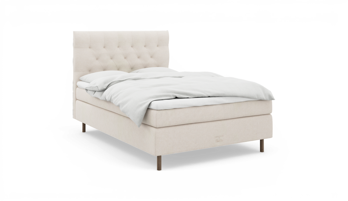 Beige polstret seng med knap-tuftet sengegavl og hvidt sengetøj, frilagt på hvid baggrund.