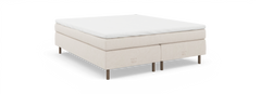 Beige kontinentalseng med hvid topmadras, træben og diskret nocturne by TEMPUR mærkning, set skråt forfra.