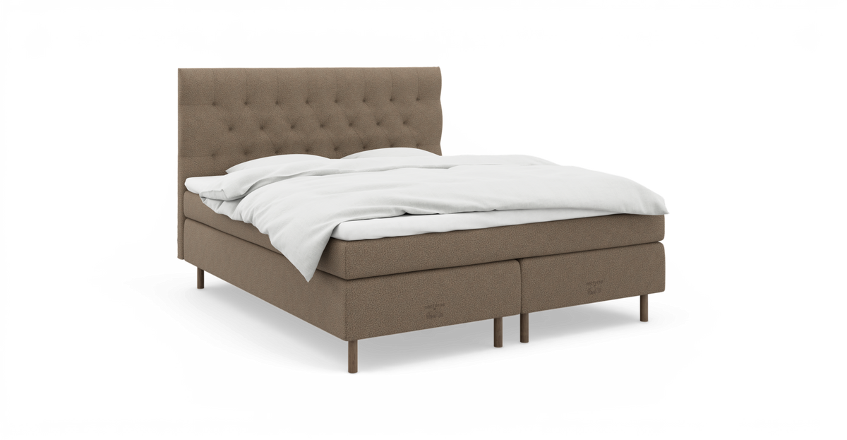 Seng med beige polstring og knapstukket gavl, hvidt sengetøj og træben.