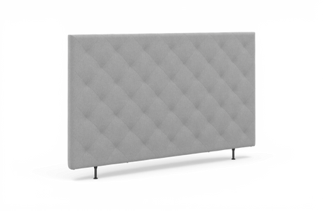 Grå polstret sengegavl med diamantquilt, fritstående på to ben.