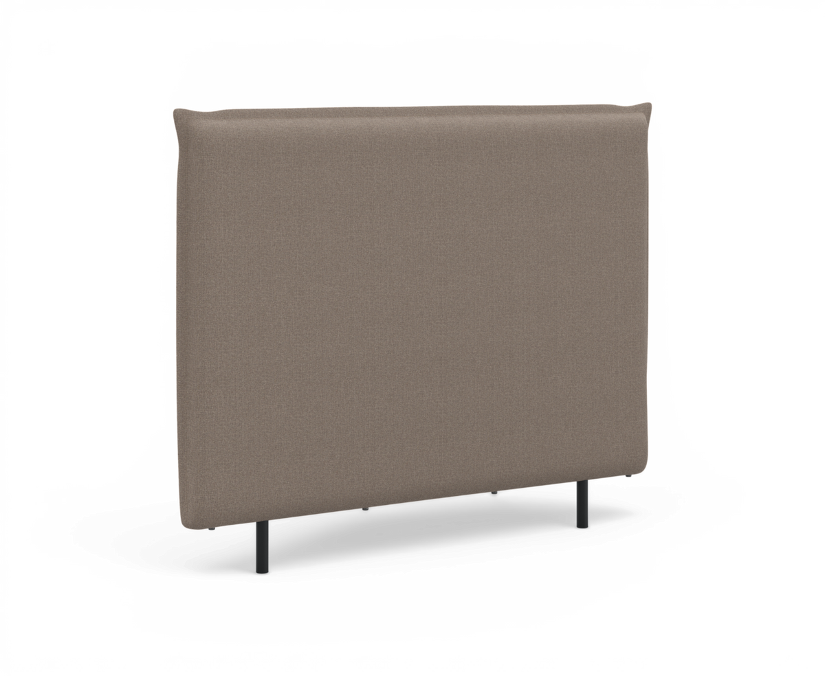 Polstret sengegavl i beige stof med slanke sorte ben, fritlagt på hvid baggrund.