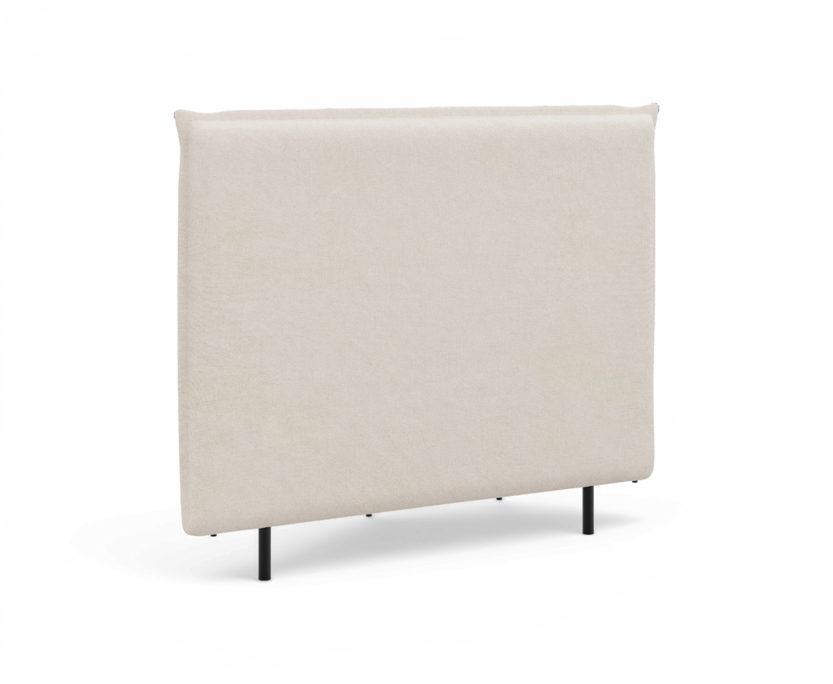 Beige polstret rektangulær sengegavl med slanke sorte ben, frilagt på hvid baggrund.