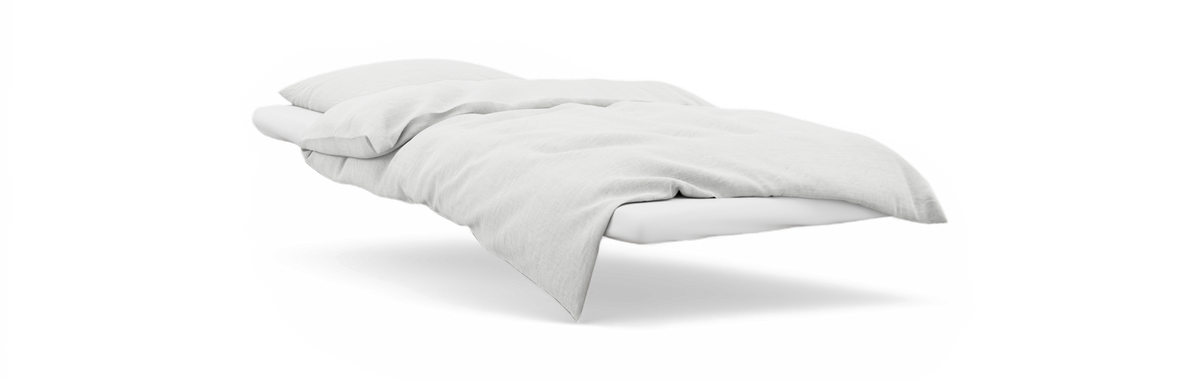 Hvid seng med hvid dyne og pude i minimalistisk stil på sort baggrund.