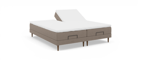 Justerbar dobbeltseng med hævet hovedende på den ene side, beige stofbase og hvid topmadras, frilagt på hvid baggrund.