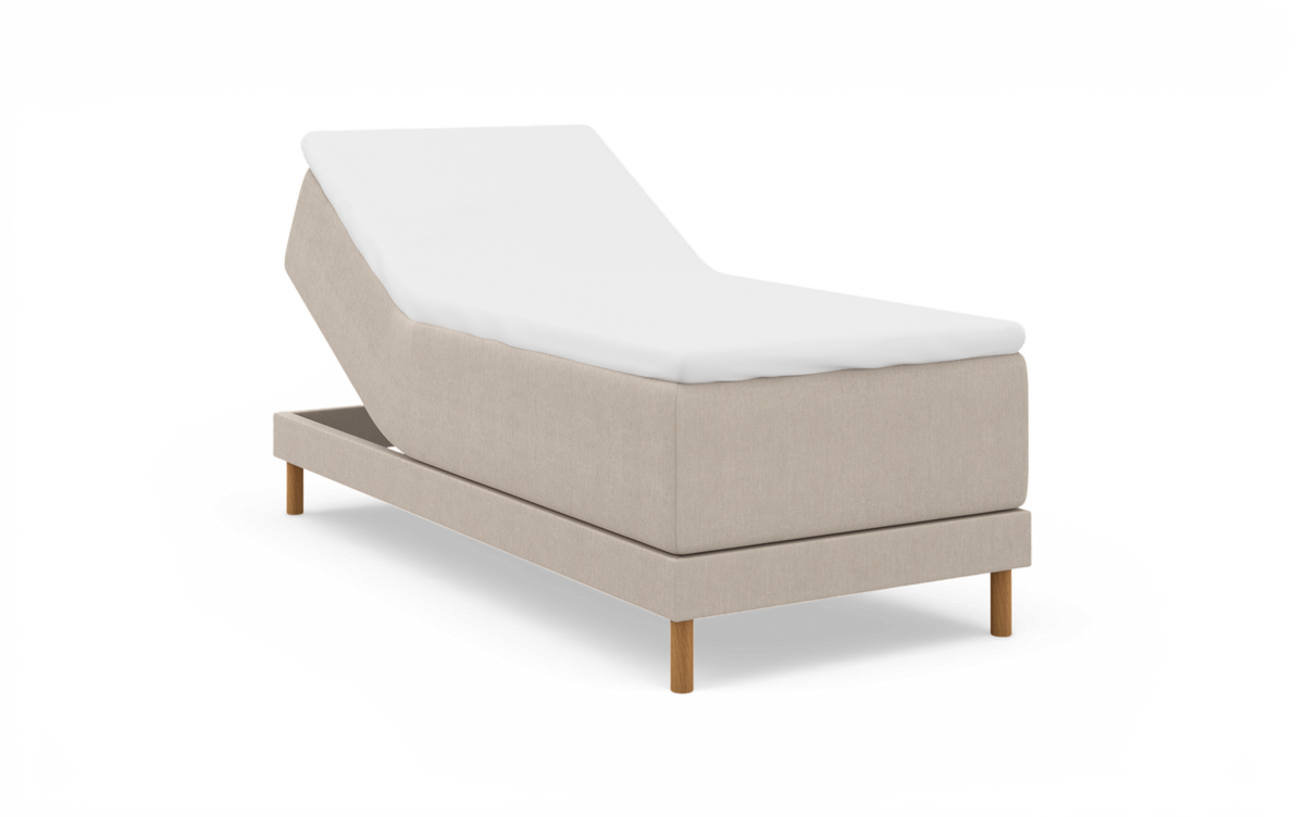 Beige regulerbar seng med hævet ryg, hvid topmadras og træben, frilagt på hvid baggrund.
