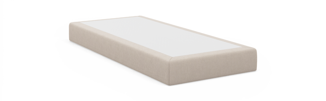 Beige sengebund med hvid top, rektangulær, frilagt mod sort baggrund.
