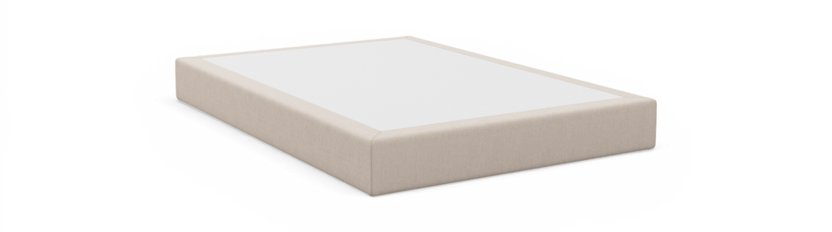 Beige stofbeklædt sengebund med hvid top, fritlagt produktfoto i studiemiljø set skråt forfra.