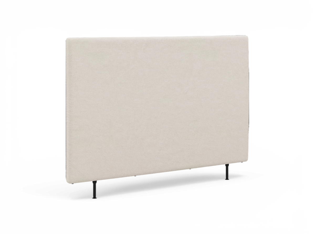 Beige, enkel polstret sengegavl med slanke sorte ben, fritlagt på hvid baggrund.