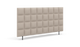 Beige polstret sengegavl med kviltet ternmønster og slanke sorte ben, frilagt på hvid baggrund.
