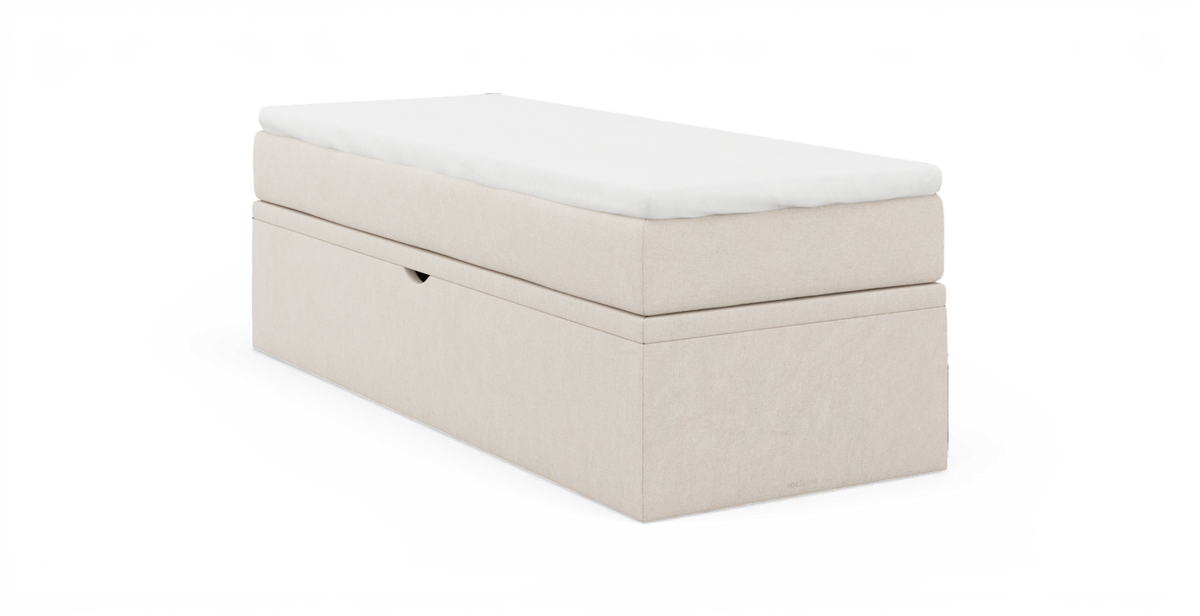 Beige polstret opbevaringsbænk med hvid pude/top, fotograferet mod neutral baggrund.