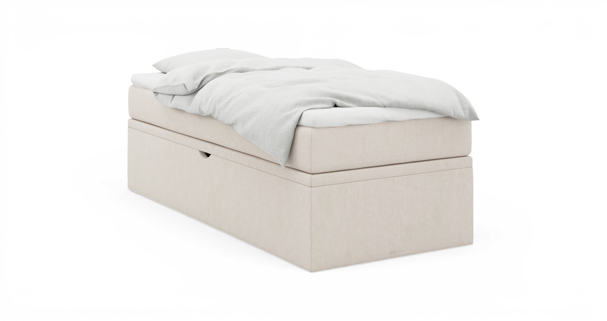 Beige polstret enkeltseng med hvid dyne og pude, frilagt.