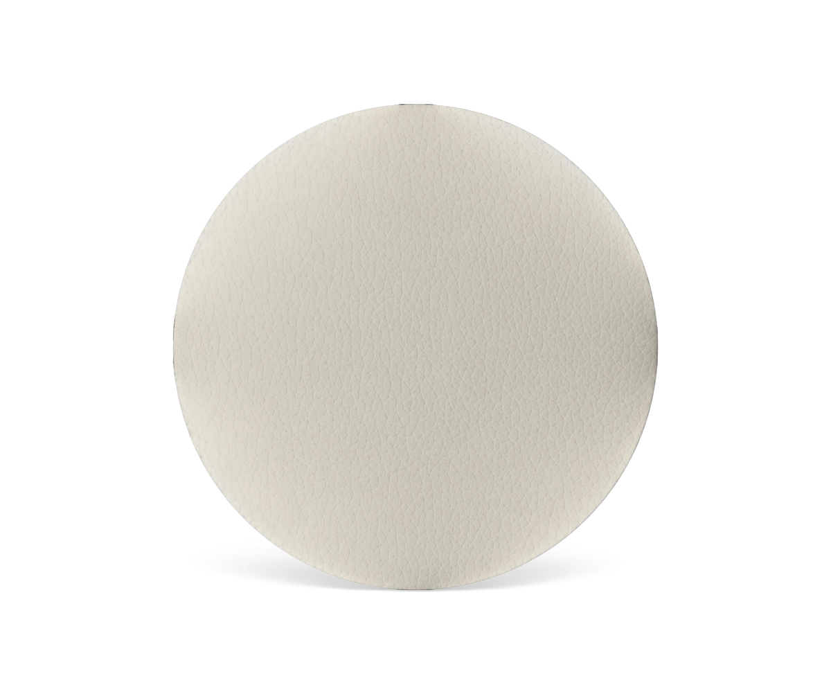 Beige læderprøve i cirkelform på sort baggrund.